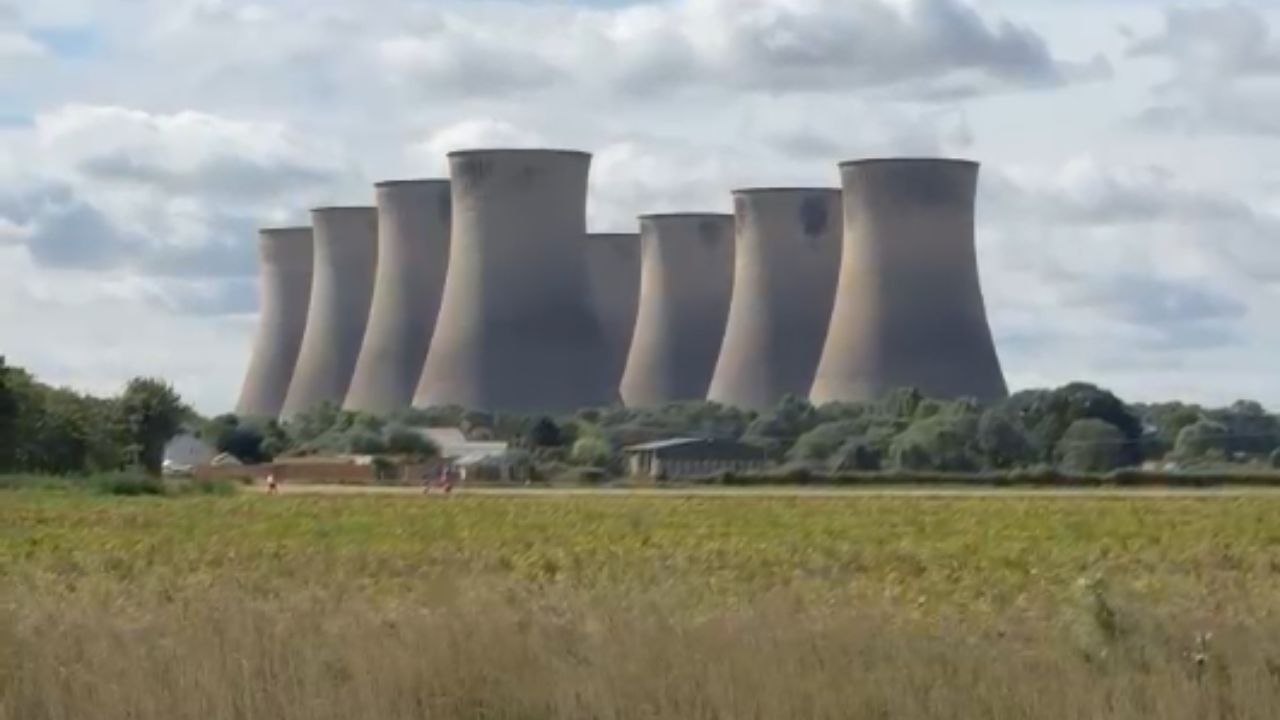 Cooling towers stand tall before collapsing into rubble in demolition