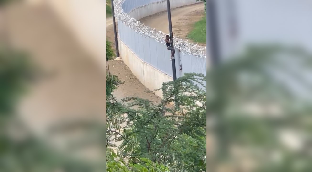 Momento en que dos haitianos cruzan la verja fronteriza