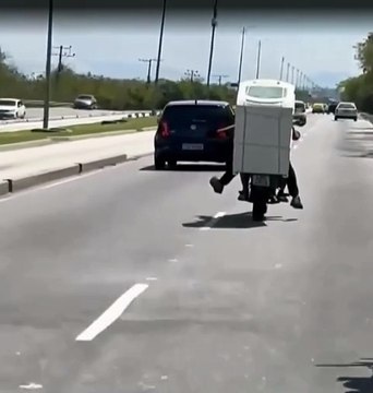 Motociclista carrega máquina de lavar na garupa na Zona Oeste
