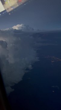 Lightning Illuminates Clouds From Airplane Window