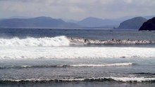 Surfer Surfing Past a Small Island