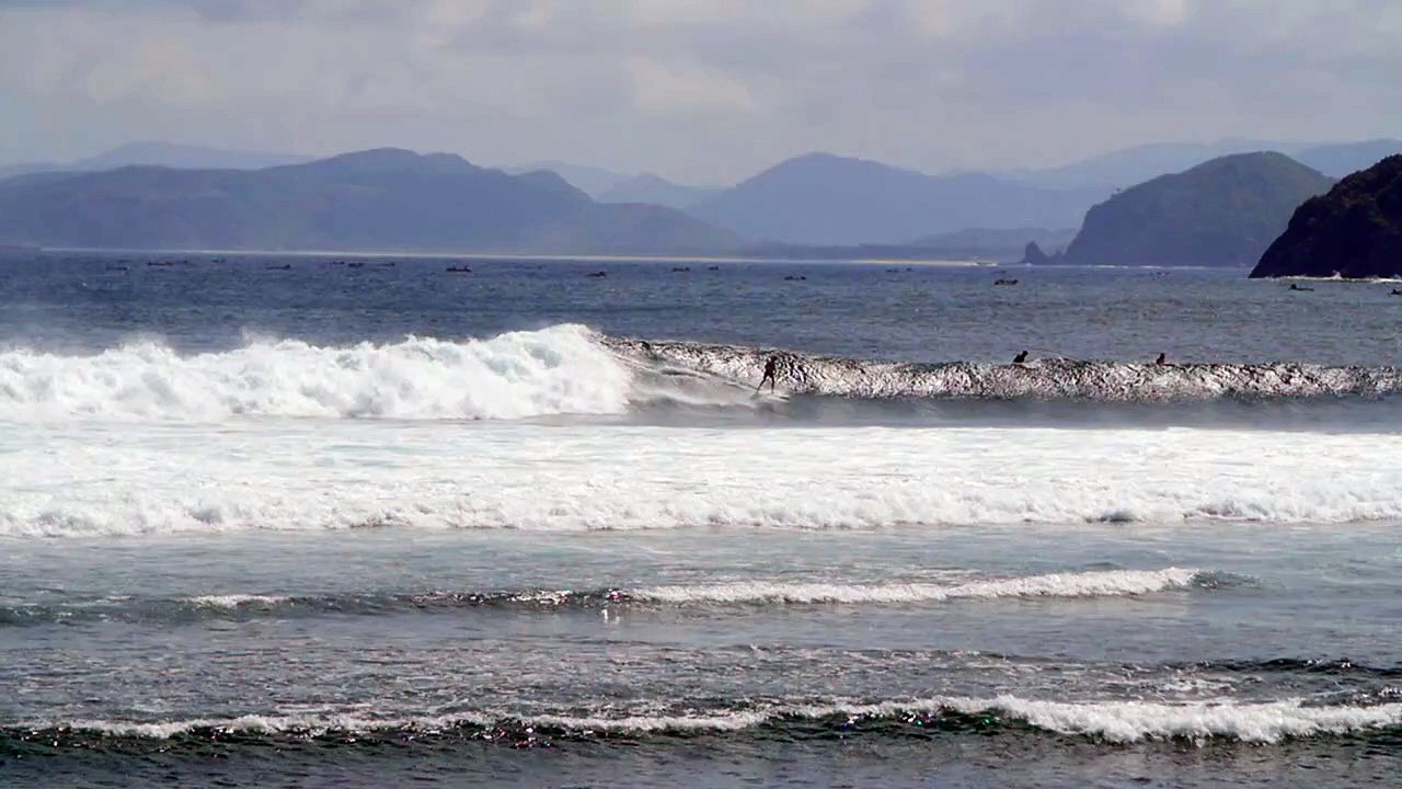 Surfer Surfing Past a Small Island