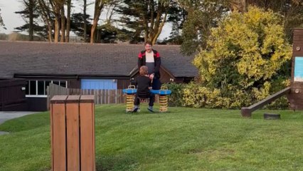 Little boy loses balance on seesaw and crashes into his dad