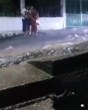 Tres jovencitas persiguen un 'pollo chuco' en una calle inundada en Cortés