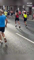 Un homme donne sa chaussure à un coureur dont la chaussure s’est déchirée en plein marathon