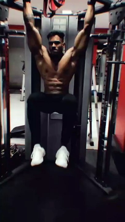 A young boy is doing a challenging workout at the gym.
