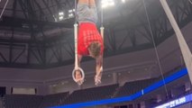 Gymnast tries to ace podium training but slips off rings
