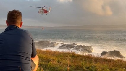 Coast Guard helicopter saves stranded person as waves crash over rock