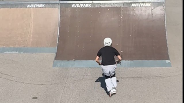Scooter rider tries a daring backflip during skatepark session but fails and crashes to the ground