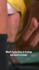 Mark Sanchez eating a hot dog on the sidelines during Jets game