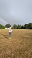 Magical moment two sisters run toward rainbow's end