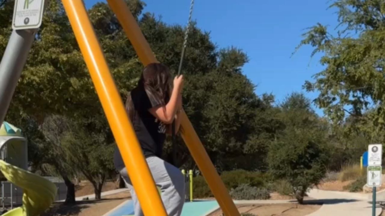 Girl rides a zipline at the local park and falls off at the end