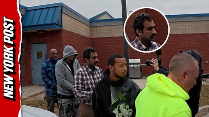 Aqeel Ahmad, fourth from the back with mustache, is walked out of the Suffolk County 6th precinct on Oct. 29.