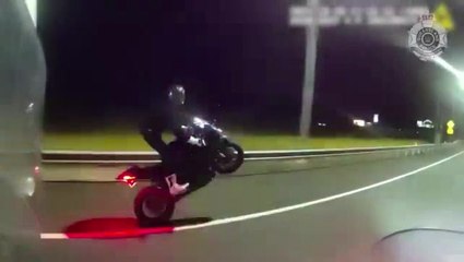 Speeding motorcyclist performs wheelie not realising police are right behind him