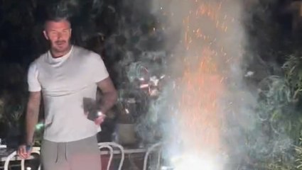 David Beckham runs for cover as firework explodes in front of him during celebration with Victoria