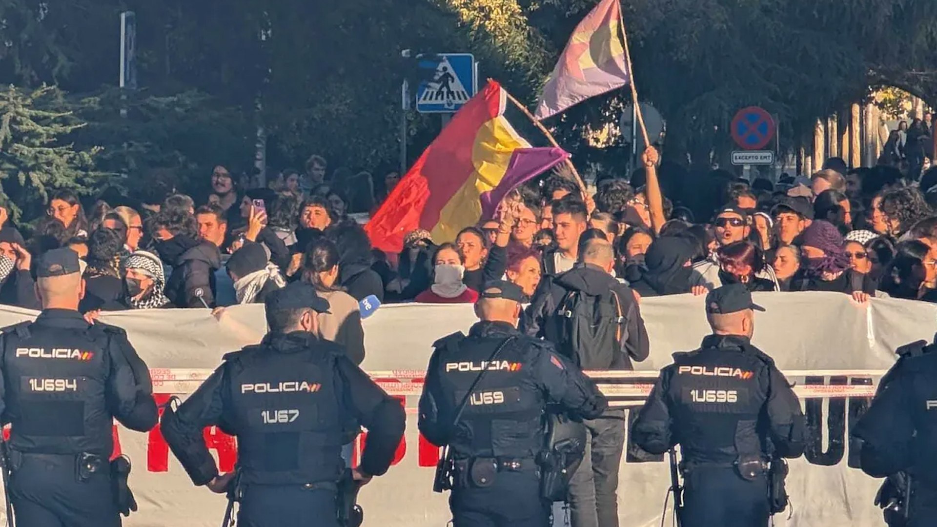 El campus de Somosaguas de la Universidad Complutense de Madrid (UCM) fue escenario este mi�rcoles de una intensa jornada marcada por el acto convocado por el activista pol�tico Vito Quiles, el cual se desarroll� sin autorizaci�n de las autoridades universitarias. La UCM hab�a recordado previamente la necesidad de tramitar cualquier actividad por los cauces oficiales para "preservar la seguridad, la convivencia y el normal desarrollo de las tareas acad�micas".
Cerca de 200 estudiantes de la Complutense se congregaron a las puertas de la Facultad de Ciencias Pol�ticas y Sociolog�a, encabezados por varios manifestantes encapuchados y exhibiendo una pancarta en la que se le�a 'Afuera fascistas de la universidad'.
Ante la posible confrontaci�n con los simpatizantes de Quiles, el delegado del Gobierno en Madrid, Francisco Mart�n, anunci� que pondr�a a los efectivos de la Polic�a Nacional �a disposici�n de lo que pida la Universidad�. Mart�n acus� indirectamente al comunicador de hacer "un flaco favor a la convivencia" y "generar situaciones de violencia".
El resultado fue un "despliegue sin parang�n" de las unidades antidisturbios, con m�s de 20 furgonetas y cientos de efectivos en la zona. La Polic�a Nacional estableci� un amplio cord�n de seguridad, controlando los accesos: "O ense�as el DNI y el correo de la universidad o no pasas".
Este dispositivo policial mantuvo separados a los dos grupos congregados (los estudiantes frente a la facultad, y los simpatizantes de Quiles con banderas de Espa�a en la parte superior de la calle). De hecho, la magnitud del despliegue impidi� que Quiles, sus nueve guardaespaldas y sus decenas de seguidores pudieran ingresar al campus, qued�ndose a m�s de 700 metros de la protesta. Si bien el cord�n evit� enfrentamientos directos, hubo un momento de tensi�n al finalizar el acto cuando la polic�a tuvo que intervenir para separar a un grupo contrario que se aproxim� a los asistentes de Quiles insult�ndoles.