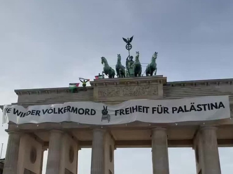 Pro-Palästina-Demonstranten hissen Banner auf dem Brandenburger Tor