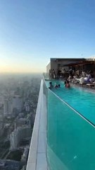 When luxury meets gravity_On a skyscraper rooftop_ the glass pool barrier shattered_ sending tons of water cascading down the tower._Swimmers froze in disbe(