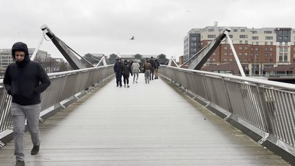 People cross Sean O'Casey bridge as storm Claudia expected to dump month's worth of rain on Ireland and UK