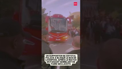 Un supporter de Crystal Palace fait semblant de faire ses lacets pour bloquer le bus de Liverpool