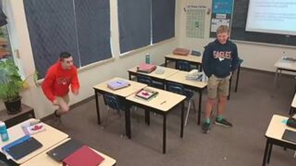 Boy Falls While Trying to Jump Over Multiple Chairs in Class