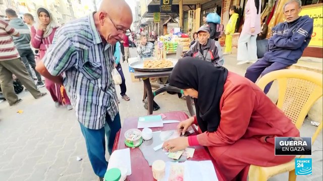 Mujer palestina repara billetes israelíes dañados en medio de la crisis económica en Gaza