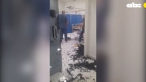 Personal de blanco del Hospital de Villa Elisa observa el destrozo generado por el familiar de un paciente fallecido