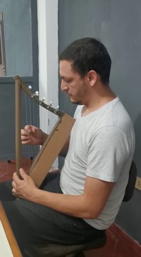 El profesor Ever Zaracho ejecuta el arpa de papel, que suena eficazmente y permite el aprendizaje de los alumnos sin dificultad.