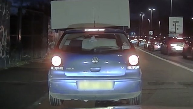 Passenger clings to sofa balancing precariously on car’s roof