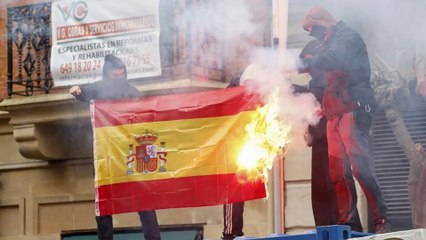 Unos encapuchados queman la bandera de España en el centro de Bilbao