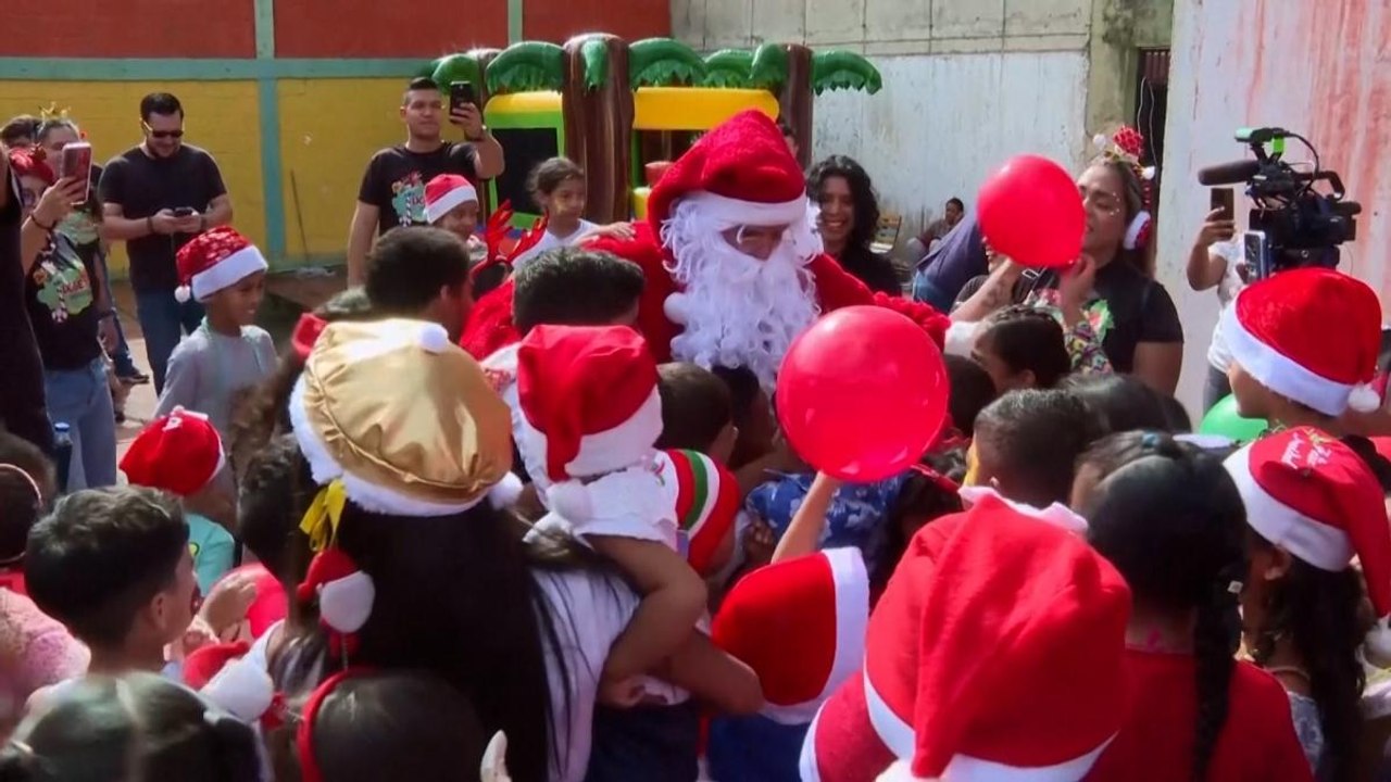 In Venezuela i giornalisti vestiti da Babbo Natale portano regali ai bambini poveri di Caracas | Il video