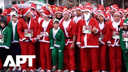 Thousands of Santas Fill Madrid Streets for Annual Red Cross Christmas Charity Run | APT