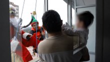 Papá Noel se descuelga de la fachada de un hospital de Barcelona para dar regalos a los niños