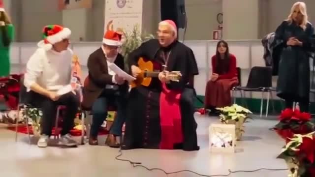 Treviso, il vescovo Michele Tomasi suona la chitarra e canta «Io Vagabondo» durante lo scambio degli auguri