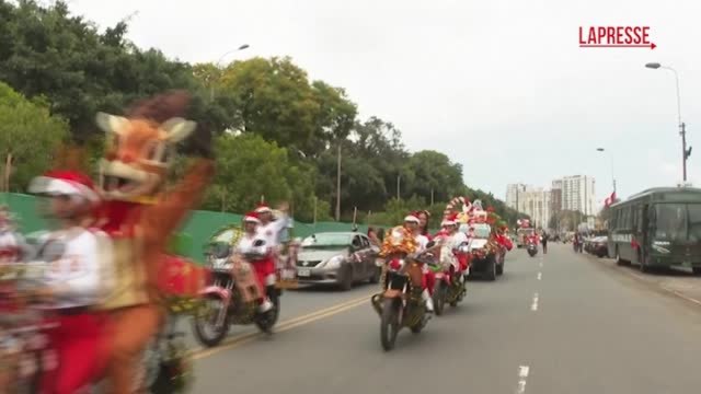 Perù, poliziotti vestiti da Babbo Natale sfilano per le strade di Lima