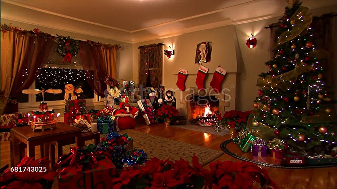 An electric train circles a tree in a living room decorated with symbols of the Christmas holiday. - HD stock videogettyimages-681743025-640_adpp