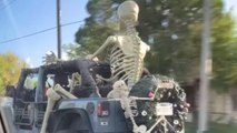 Halloween spirit on full display as huge skeleton enjoys a ride in the back of a Jeep