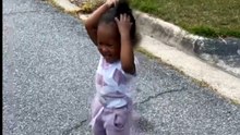 Adorable toddler tries to throw a stick and ends up hitting her head