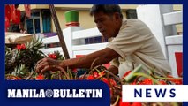 Vendor arranges and displays ube, pineapples for sale along Ongpin Street in Binondo, Manila
