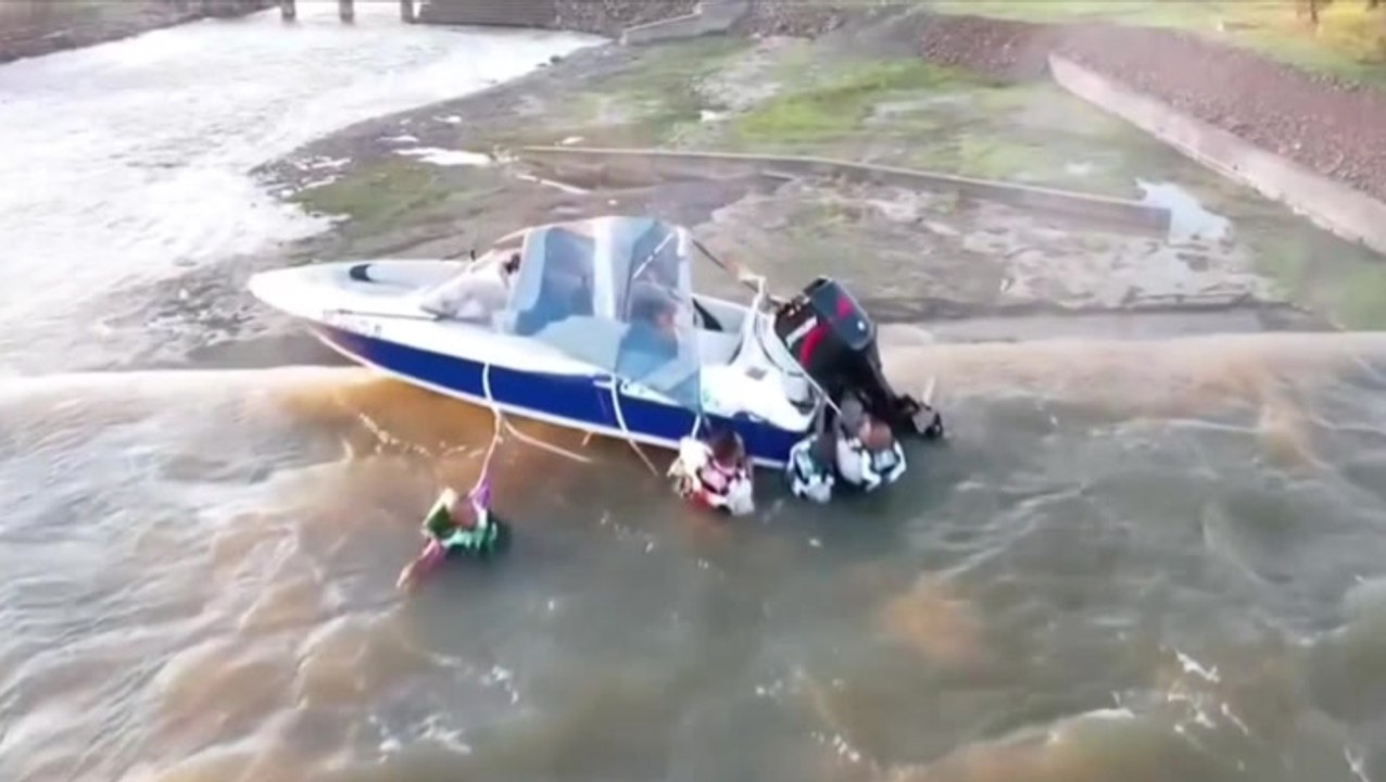 Watch: Men clinging to boat dangling over edge...