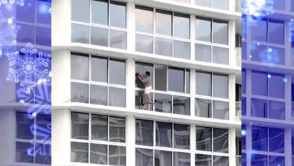 Mujer se pone en peligro al limpiar ventanas de edificio
