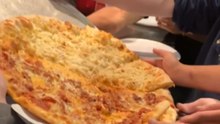 Woman watches her Hell's Kitchen pizza fall as the pan suddenly tips off the stand