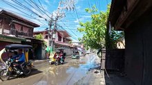 Crossing The Wet Road on Hipolito Street in Malolos, Bulacan, Philippines
