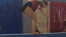 Balance beam routine goes awry as a gymnast fumbles a backflip