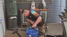 Trusted snake catcher handles his first case of red-bellied black snake stuck inside vacuum cleaner