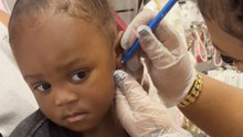 Little girl gets her ears pierced for first time and stays completely calm