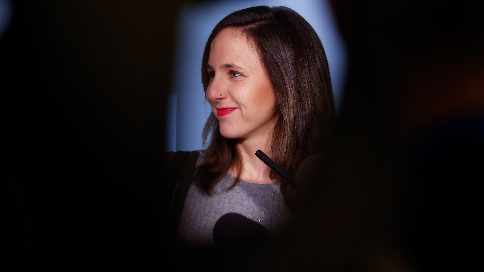 La estabilidad de la legislatura de Pedro S�nchez vuelve a tambalearse por el flanco izquierdo. En un movimiento estrat�gico que supone un jarro de agua fr�a para las aspiraciones del Gobierno, Podemos ha condicionado cualquier apoyo a la delegaci�n de competencias de inmigraci�n a Catalu�a &mdash;exigencia clave de Junts&mdash; a la ejecuci�n previa de una regularizaci�n masiva de personas migrantes. Esta decisi�n no solo bloquea el di�logo con los de Carles Puigdemont, sino que amenaza con dinamitar los puentes necesarios para la aprobaci�n de los pr�ximos Presupuestos Generales del Estado.
La secretaria general de la formaci�n morada, Ione Belarra, ha sido tajante al marcar las l�neas rojas de su partido en el Congreso de los Diputados. Seg�n la l�der de Podemos, el Gobierno debe demostrar con hechos, y no con promesas, su compromiso con los derechos humanos antes de entrar en debates competenciales. "Primero papeles, que esa regularizaci�n est� implementada y despu�s Podemos no tiene ning�n problema con las delegaciones de competencias a las comunidades aut�nomas", ha sentenciado Belarra para dejar claro que su formaci�n solo negociar� cuando se verifique que la regularizaci�n de m�s de 500.000 personas es efectiva.
La formaci�n argumenta que ya no aceptan compromisos que puedan quedar en el olvido, puesto que el Ejecutivo "ha demostrado en numerosas ocasiones que promete y no cumple". Por ello, exigen ver la medida "implementada" antes de dar cualquier paso en la cesi�n de poderes a la Generalitat.
Este cambio de postura de Podemos supone un problema de cronometraje letal para el Palacio de la Moncloa. Si se tiene en cuenta que el plan de regularizaci�n del Ejecutivo estima que las solicitudes se empezar�n a presentar a "principios de abril", la negociaci�n de las competencias de inmigraci�n se retrasar�a, en el mejor de los casos, hasta los meses de mayo, junio o incluso julio.
Este retraso impide al Ejecutivo recomponer los v�nculos con Junts, que reclama la delegaci�n de competencias de forma inmediata. Sin este acuerdo, la presentaci�n y votaci�n de las cuentas p�blicas se adentra en un escenario de incertidumbre total, ya que el proceso de regularizaci�n estar� abierto, te�ricamente, hasta "el 30 de junio de 2026".
M�s all� de los plazos, Podemos ha expresado su rechazo frontal al contenido ideol�gico del acuerdo alcanzado entre socialistas y posconvergentes. Belarra ha denunciado la presencia de tintes racistas "no solo en el pre�mbulo" de la ley acordada, sino tambi�n en su articulado, el cual pretende modificar.
La l�der morada ha cargado con dureza contra la pol�tica de extranjer�a del Estado, tild�ndola de "abiertamente racista" por mantener herramientas como los Centros de Internamiento de Extranjeros (CIE) o las redadas por perfil �tnico. Seg�n su visi�n, el enfoque actual se basa en una securitizaci�n que se traduce en "represi�n contra las personas migrantes", algo que su partido no est� dispuesto a avalar con su voto.
Finalmente, Belarra ha advertido que, aunque esperan "una reacci�n muy fuerte por parte de la derecha" ante este avance en derechos, su formaci�n los defender� "con u�as y dientes" en el Parlamento. Con este escenario, el Gobierno se ve obligado a elegir entre acelerar la regularizaci�n de inmigrantes o arriesgarse a una pr�rroga presupuestaria por falta de apoyos en su bloque de investidura.