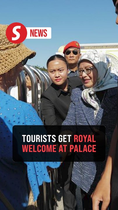 Queen greets tourists at entrance to Istana Negara