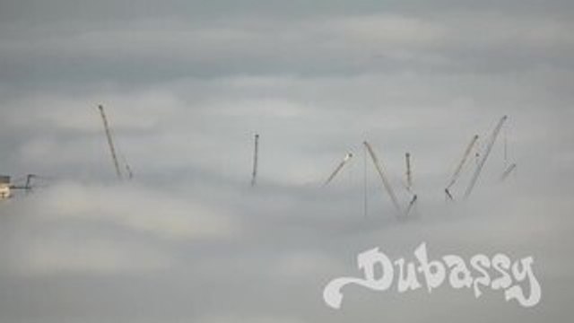 Construction Cranes Rise Above Clouds