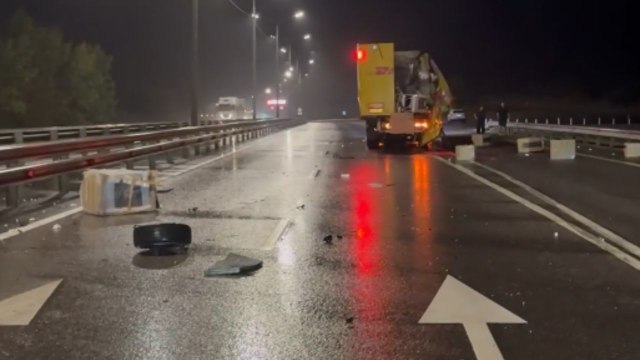 Aftermath of accident on Russian highway shows a badly damaged car and an injured person